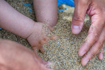 Father with little son have fun playing in the sand on Crete island, Greece