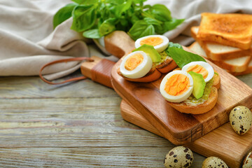 Tasty sandwiches with egg and avocado on table