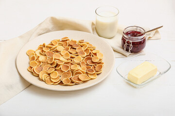 Obraz na płótnie Canvas Plate with tasty mini pancakes, butter, jam and milk on table