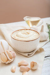 Bowl with garlic sauce on table