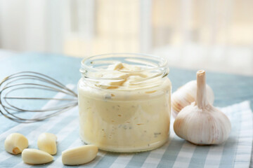 Jar with garlic sauce on table
