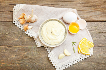 Bowl with garlic sauce and ingredients on table