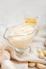 Gravy boat with garlic sauce on grey background