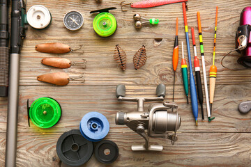 Different fishing equipment on wooden background