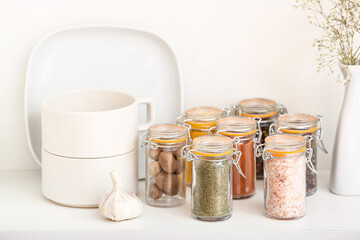 Jars with different spices on table in kitchen