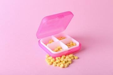 Container with folic acid pills on color background