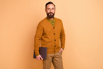 Photo of intelligent mature hold laptop wear pants isolated over beige color background