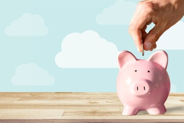 Businessman putting coin into the piggy bank