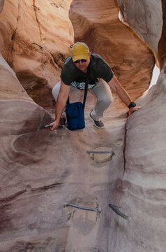 fat man descends into a narrow crevice in the mountains