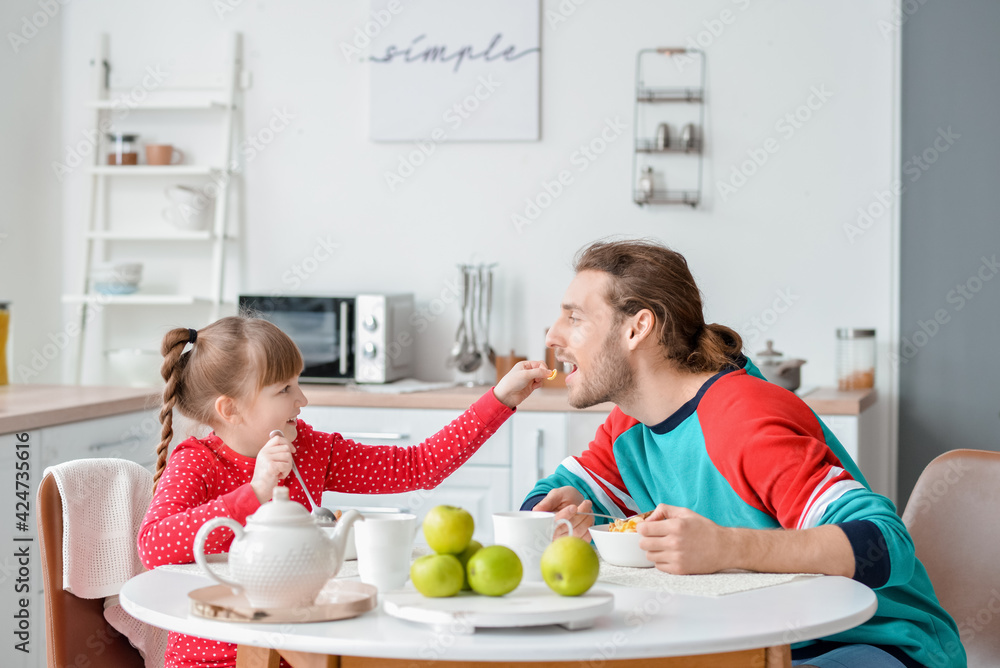 Poster Happy father and daughter having breakfast at home