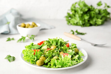 Plate of fresh salad with vegetables on light background