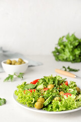 Plate of fresh salad with vegetables on light background