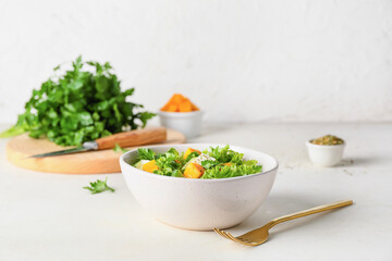 Fototapeta na wymiar Bowl of fresh salad with vegetables on light background
