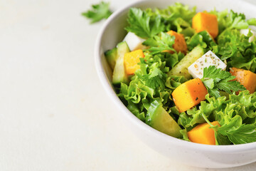 Bowl of fresh salad with vegetables on light background