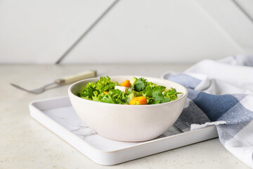 Bowl of fresh salad with vegetables on light background