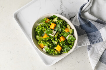 Bowl of fresh salad with vegetables on light background