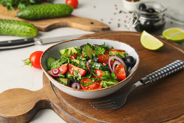 Bowl of fresh salad with vegetables on table