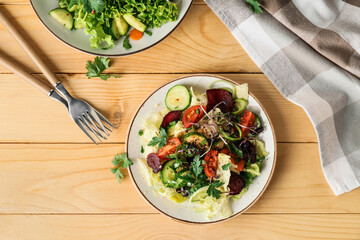 Plate of fresh salad with vegetables on wooden background