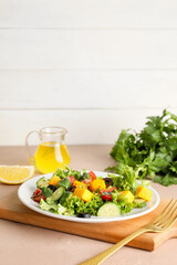 Plate of fresh salad with vegetables on color background