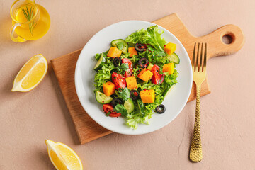 Plate of fresh salad with vegetables on color background