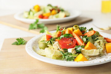 Plates of fresh salad with vegetables on light wooden background