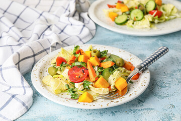 Plate of fresh salad with vegetables on color background
