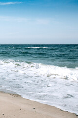 Fototapeta na wymiar Deep blue stormy ocean water and blue sky background. Horizon of the sea