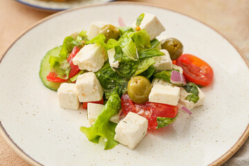 Plate with fresh Greek salad on table, closeup