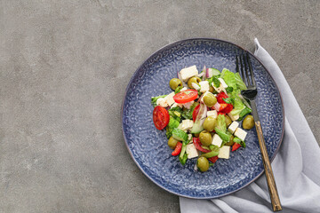 Plate with fresh Greek salad on grunge background