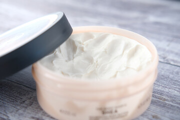 Close up of face cream in a container on wooden background