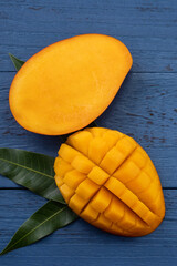 Top view design concept of beautiful mango fruit over blue table background.