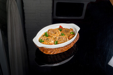 Casserole served in a glass dish filmed on a black background
