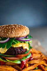 Homemade plant based burger with sweet potato fries around. Vegan.