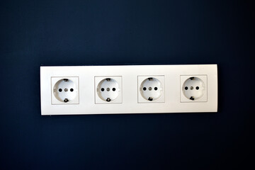 White electrical outlets on a blue wall with Internet connectors