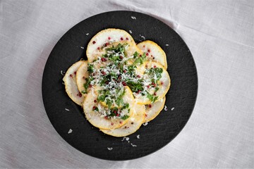 Sizilianische Vorspeise mit Scheiben einer Zitronatszitrone, auch Cedro genannt, Rucola, rosa Beeren, Parmesankäse und einer Vinaigrette