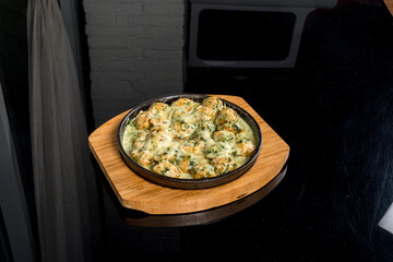 Fried dumplings served in a cast iron skillet on a wooden board