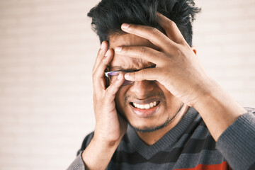 Close up of sad man covering face with hand.