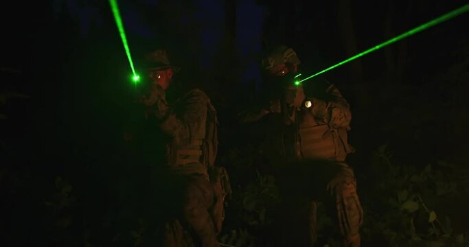 fighters of a special unit move through the forest at night with fire in backgorund 