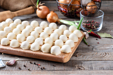 Frozen semi-finished products dumplings on the wooden board. Copy space, horizontal