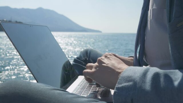 freelancer businessman working remotely on laptop at the beach