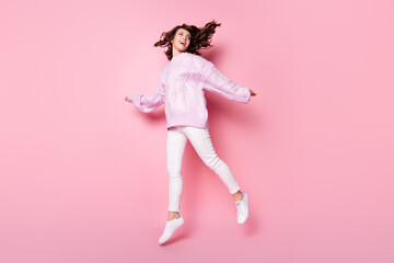 Full length body size view of attractive cheerful wavy-haired girl jumping having fun going isolated on pink pastel color background