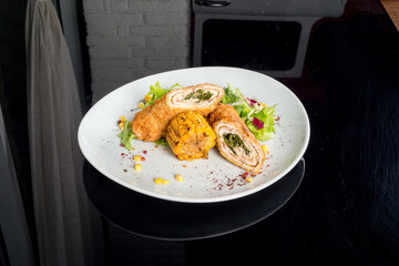 Meatloaf served with fresh herbs and corn on a white plate