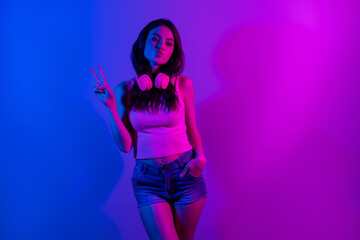 Photo of young beautiful stunning girl showing v-sign pout lips wear headphones isolated on neon blue color background