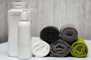 Fototapeta na wymiar A set for washing hair, shampoo, balm and towels in the bathroom.