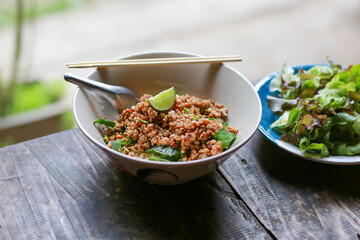 Pork chops in a bowl of noodles look delicious. There is a lemon on top, dried noodle soup with minced pork. Food of Thailand