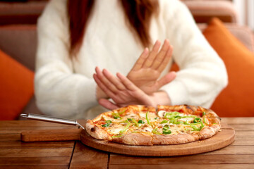 losing weight woman refuses baking and fatty foods. hand gesture I not eat pizza. woman on diet or...