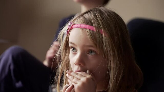 Cute little girl taking a bite of chocolate.