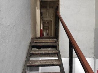 Narrow fire passage with a ladder and fire extinguishers on the floor