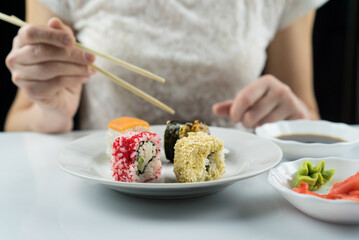 girl eats sushi rolls with chopsticks, philadelphia, california