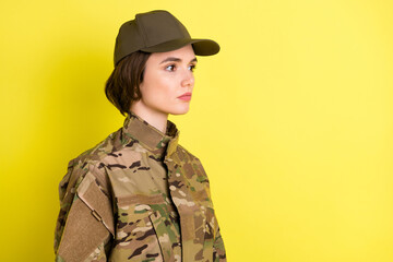 Profile portrait of charming focused girl look attentively empty space wear hat isolated on yellow color background